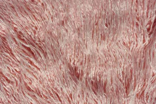 Texture of pink fur. Pink abstract background. Light pink faux fur like merino skin.