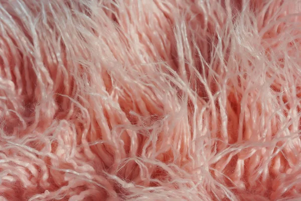 Texture of pink fur. Pink abstract background. Light pink faux fur like merino skin.