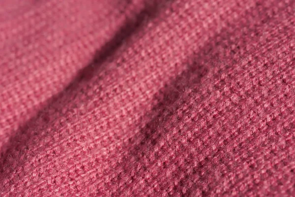 Texture of knitted pink fabric. Pink abstract background. Light pink thick winter fabric