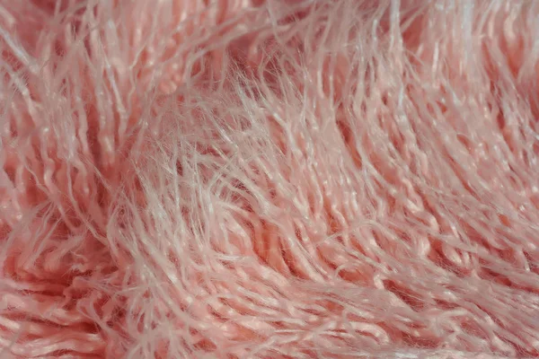 Texture of pink fur. Pink abstract background. Light pink faux fur like merino skin.