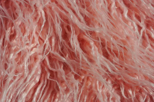 Texture of pink fur. Pink abstract background. Light pink faux fur like merino skin.