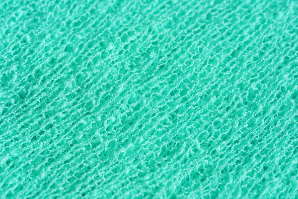Texture of knitted fabric in aqua color. Knitted abstract background turquoise. Bright green sea fabric.