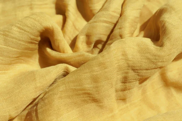 Açık sarı kumaş dokusu. Bej tekstil malzemesi dokusu. Sarı-yeşil eşarp.