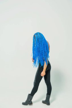 Beyaz arka planda mavi at kuyruklu Rus kızı. Bir kadının kafasında mavi zizi. Hafif bir arka plan üzerinde dreadlocks ile Eğitimli kız
