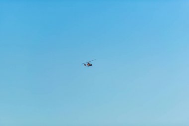 Helikopter mavi gökyüzüne karşı uçuyor. Gökyüzünde hava taşımacılığı. Kırgızistan'da dinlenin. Issyk-Kul gölüne gezi.