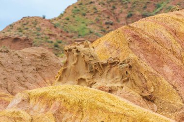 Kırgızistan'da Kanyon Masalı. Kumlu kırmızı oluşumlar. Kanyonun tepelik alanı. Issyk-Kul Gölü bölgesinde doğa.