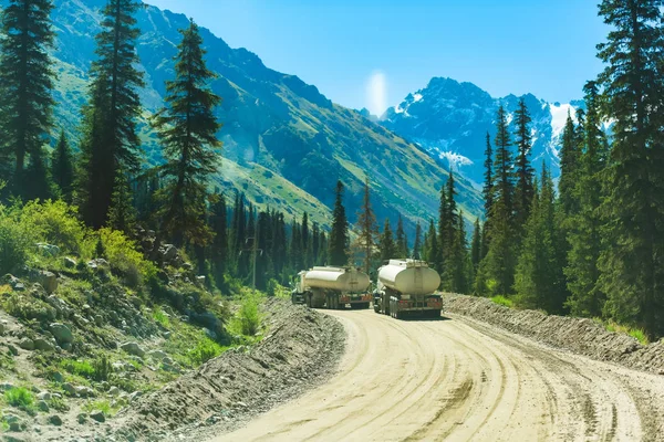 Fuel trucks in the mountains. Barskoon Gorge. Coniferous vegetation on the mountain slopes.  Rest in Kyrgyzstan. Trip to Issyk-Kul lake.