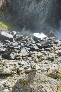 Vadideki Barskoon şelalesi. Taşlar şelaleye karşı üst üste yığılmış. Kırgızistan'da dinlenin. Issyk Kul gölüne gezi.