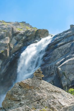 Vadideki Barskoon şelalesi. Taşlar şelaleye karşı üst üste yığılmış. Kırgızistan'da dinlenin. Issyk Kul gölüne gezi.