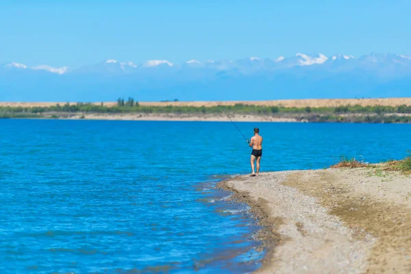 Ένας Άντρας Καλάμι Ψαρέματος Είναι Στη Λίμνη Αναπαύσου Στο Κιργιζιστάν — Φωτογραφία Αρχείου