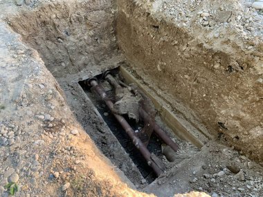 Isıtma borularının değiştirilmesi. İçme suyu ile boruların onarımı. Kazılan toprağın dokusu. Toprak altında metal boru.