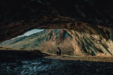 Mağaranın çıkışında bir adam. Dağlarda yürüyen bir adam. Güney Kazakistan dağlarında yürüyüş adam.