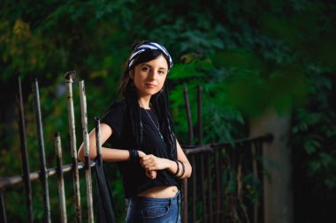 Parkta siyah beyaz dreadlocks ile kız. Dreadlocks ile genç bir kadın. Siyah bir T-shirt ve kot açık hippi tarzında Kız modeli