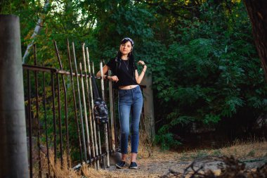 Parkta siyah beyaz dreadlocks ile kız. Dreadlocks ile genç bir kadın. Siyah bir T-shirt ve kot açık hippi tarzında Kız modeli