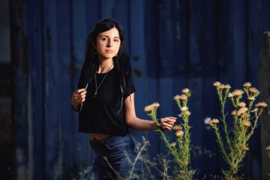 Bir devedikeni ve dikenleri ile koyu mavi ahşap arka plan üzerinde siyah ve beyaz dreadlocks ile Kız. Dreadlocks ile genç bir kadın. Siyah bir T-shirt ve kot açık hippi tarzında Kız modeli