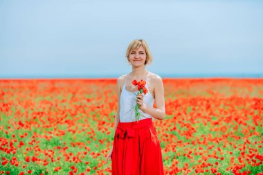 Haşhaş tarlasındaki kız. Elinde haşhaş tarlasında bir buket haşhaş ile genç kadın. 