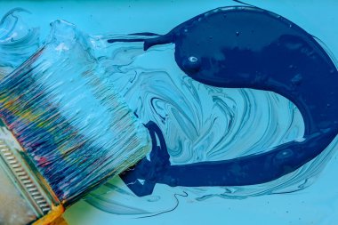 İki sıvı boyalar koyu mavi ve açık mavi renklerbir fırça ile karıştırma. Akrilik lateks boya boyama. Mavi boya yakın çekimboya sanat geniş fırça.