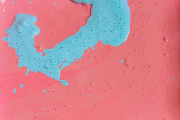 The texture of the mix of two liquid colors is light blue and pink. Beautiful abstract pink light blue two color background. Coloring acrylic latex paint