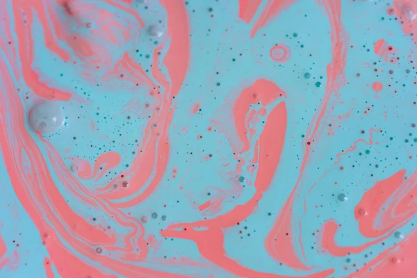 The texture of the mix of two liquid colors is light blue and pink. Beautiful abstract pink light blue two color background. Coloring acrylic latex paint