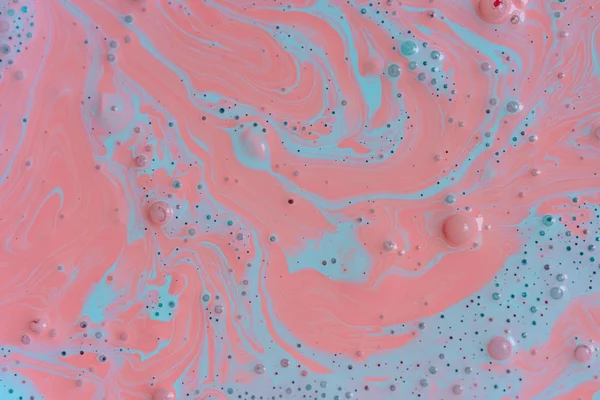 The texture of the mix of two liquid colors is light blue and pink. Beautiful abstract pink light blue two color background. Coloring acrylic latex paint
