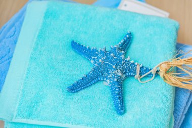 Denizyıldızı kabuklu mavi havlu yığını. Otelde havlular var. Tatil ve yüzme sezonuna hazırlık.