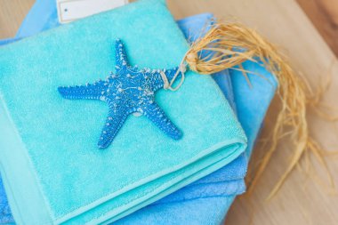 Denizyıldızı kabuklu mavi havlu yığını. Otelde havlular var. Tatil ve yüzme sezonuna hazırlık.