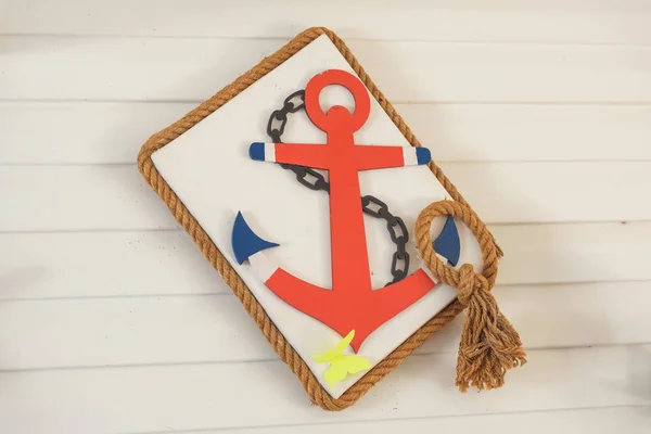 Decorative wooden anchor and ropes in the water park. Decorating in the nautical style of children\'s birthday. Sea anchor from plywood.