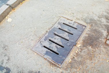 Asfalt yolda yağmur suyu akıntısı. Metal fırtına kanalizasyon. Gri asfalt.