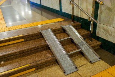 Metrodaki rampa. Merdivenlerde metal rampa. Engelliler için asansör.