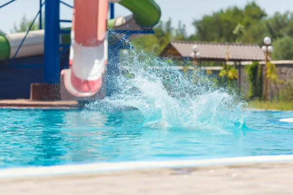 男はウォーターパークで滑り台を転がした プールの水の飛沫 ウォーターパークでの夏休み — ストック写真