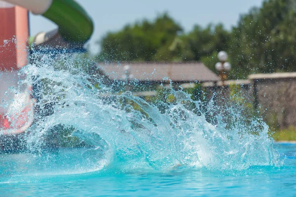 男はウォーターパークで滑り台を転がした プールの水の飛沫 ウォーターパークでの夏休み — ストック写真