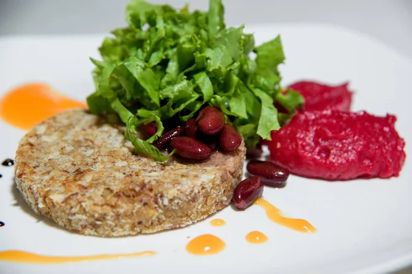 Vegetarian dish. Food without salt and oil. Vegetarian cutlets with lettuce and beans.