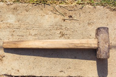 Eski balyoz beton yüzeyde yatıyor. Evde el perküsyon aleti.