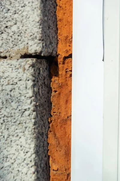 Cinder blok duvar. Pencerede inşaat köpüğü. Gri cüre bloğun un dokusu.