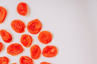 Beyaz bir arka plan üzerinde portakal kuru kayısı. Kuru kayısı deseni. Beyaz arka planda oryantal kurutulmuş meyveler.