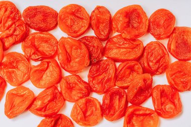 Beyaz bir arka plan üzerinde portakal kuru kayısı. Kuru kayısı deseni. Beyaz arka planda oryantal kurutulmuş meyveler.