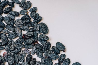 Beyaz arka planda siyah kuru üzüm. Siyah kurutulmuş üzüm deseni. Beyaz arka planda oryantal kurutulmuş meyveler.