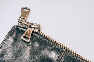 Beyaz arka plan üzerinde deri ceket üzerinde çelik fermuar. Ceketin üzerinde metal toka var. Demir güçlü bağlantı elemanı bir yıldırım. Toka üzerinde metal sürgü