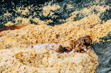 Büyük bir kazanda gerçek Özbek pilavı. Taşkent'teki pilav merkezi. Özbekistan'da ulusal yemekler pişirmek. Kazanda etli pilav. Geleneksel pilav pişirme