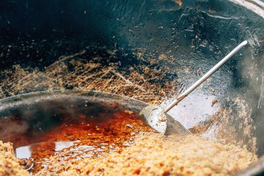 Büyük bir kazanda gerçek Özbek pilavı. Taşkent'teki pilav merkezi. Özbekistan'da ulusal yemekler pişirmek. Kazanda etli pilav. Geleneksel pilav pişirme