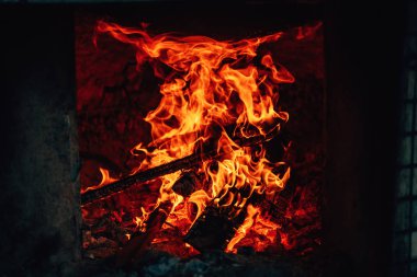 Ateşin dokusu. Pilav pişirmek için Özbek fırını. Yemek pişirmek için Kazak tandırı. Koyu arka plandaki alevler