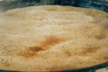 Büyük bir kazanda pilav pişirmek. Özbek ulusal pirinç yemeği. Taşkent'te pazarda yürüyüş.