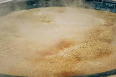 Büyük bir kazanda pilav pişirmek. Özbek ulusal pirinç yemeği. Taşkent'te pazarda yürüyüş.