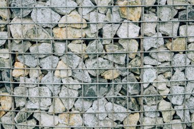 Metal bir ızgaranın arkasındaki taşlar. Taşkent şehrini dolaşın. Gölüzerindeki iskele.