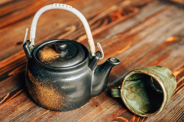 A teapot of tea with mugs on a wooden background. Dishes for Chinese-style tea. Tea in an Asian cafe. Old Antiquarian Tableware for Hot Drinks