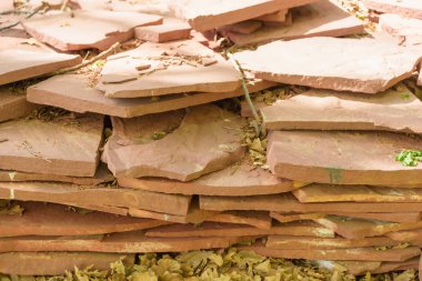 Yeşil çimenlerin üzerinde duran dekoratif taş karolar. Yapı malzemesi. Doğal taş karolar.