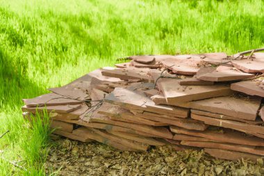 Yeşil çimenlerin üzerinde duran dekoratif taş karolar. Yapı malzemesi. Doğal taş karolar.