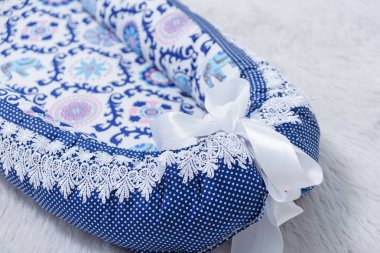Yeni doğanlar için yatak kozası. Bebek karyolası için yatak. Şerit ve dantel ile dekore edilmiş mavi yatak.