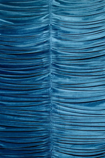 Blue velvet curtain. Texture of velvet fabric. The folds in the material.