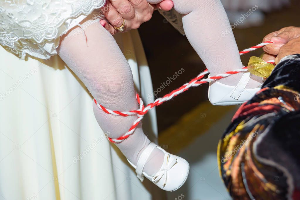 Baby's first steps. Bandaging the baby's legs with ribbons. Kazakh folk tradition. Cutting fetters.